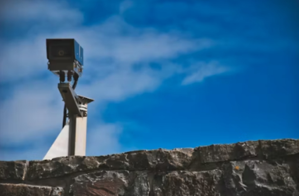 a security camera against a blue sky