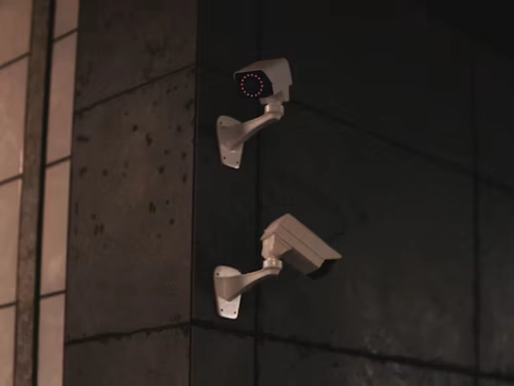 two white surveillance cameras facing different directions