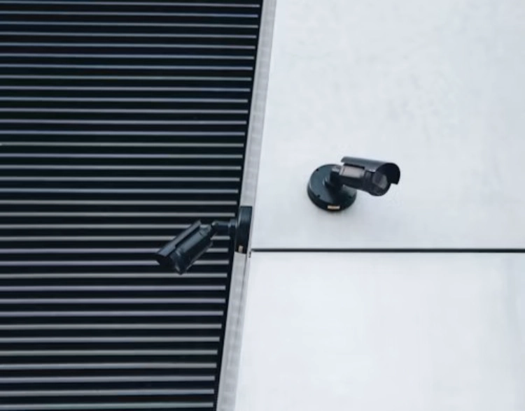 two black surveillance cameras facing opposite sides