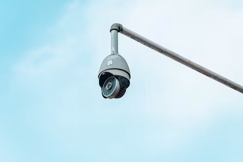 a surveillance camera against a blue sky